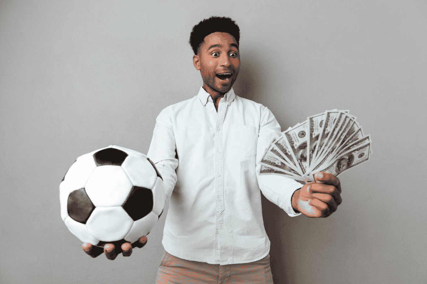 man holding a football and cash