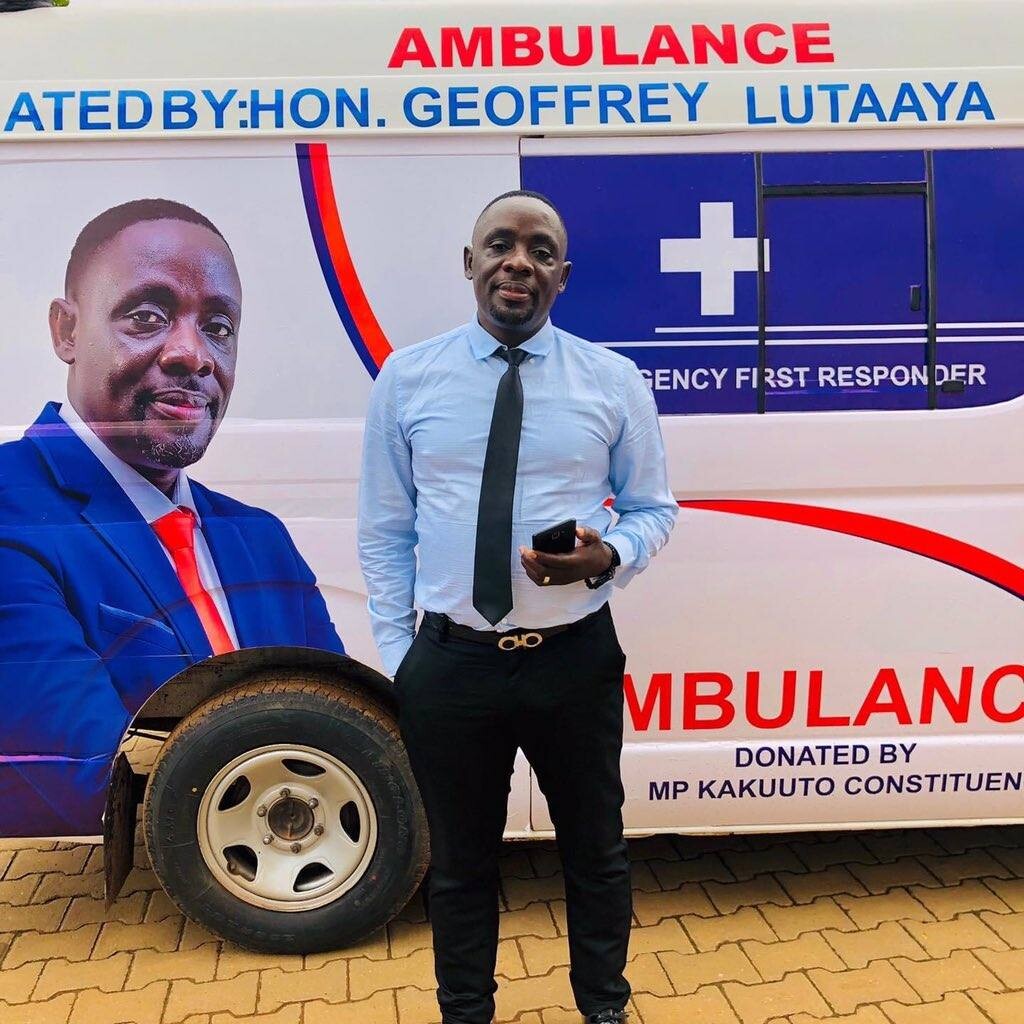 Geoffrey Lutaaya stands next to his ambulance 