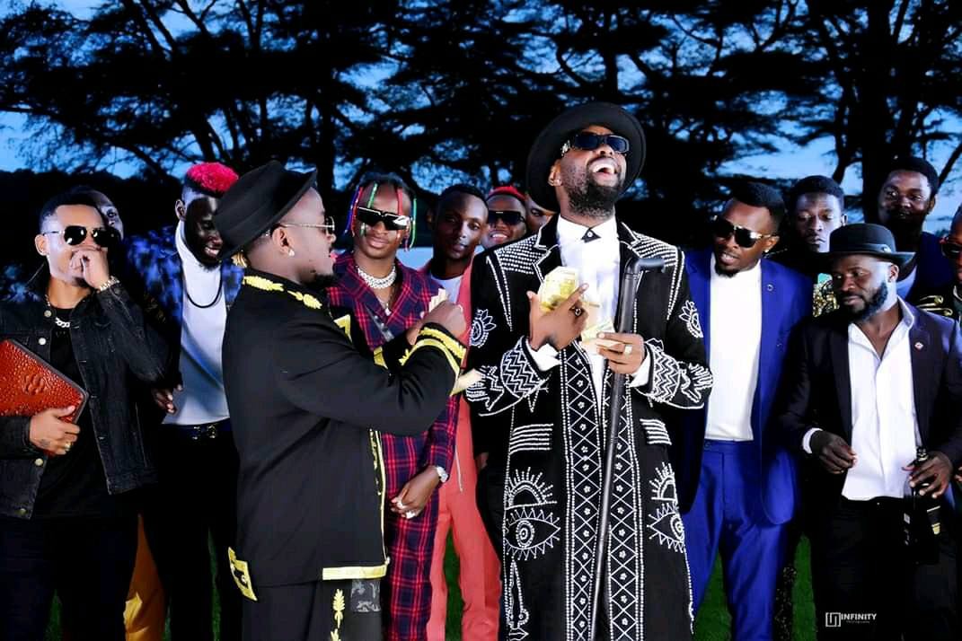 Ykee Benda splashes money on Eddy Kenzo during the Semyekozo video shoot at Speke Resort Munyonyo last year (late November 2019)