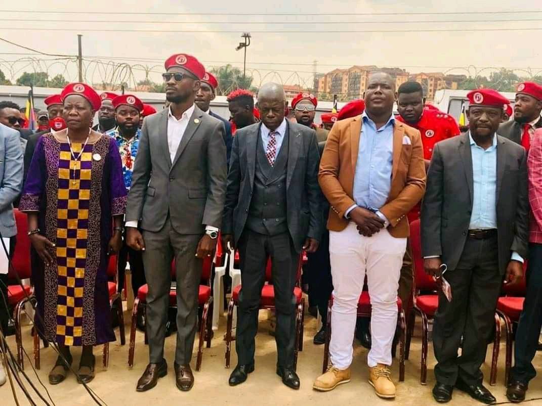 Basajja Mivule (Center) stands next to Bobi Wine (in shades) on the day he joined NUP