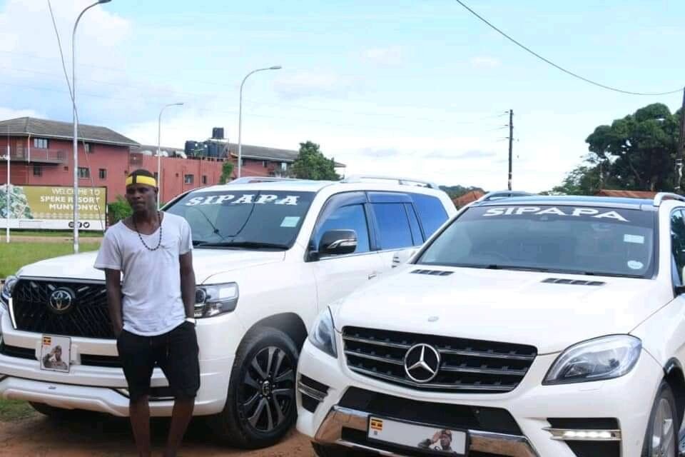 Sipapa stands next to some of the cars he owns 