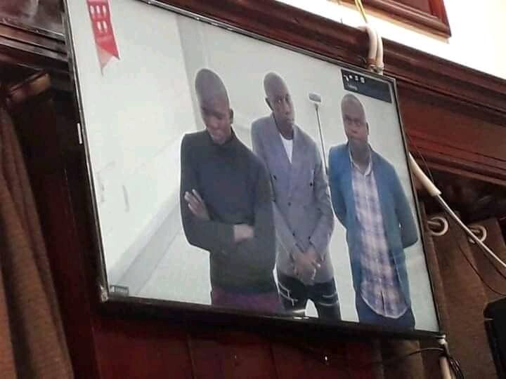 Kayz (middle) and his friends attend court via video link from Kitalya Prison 