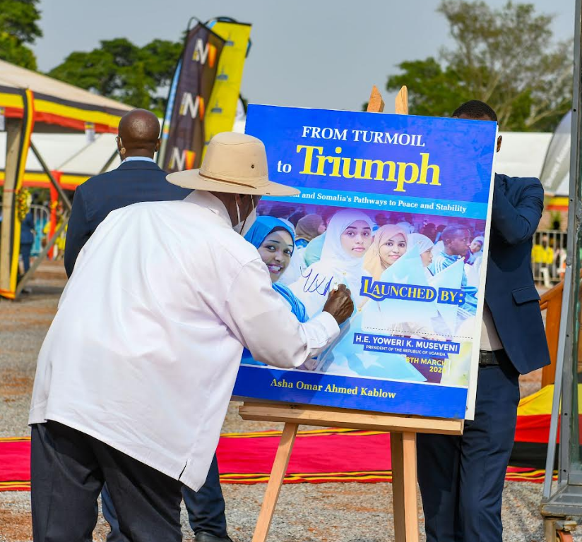 Museveni signs a potrait of a muslim lady